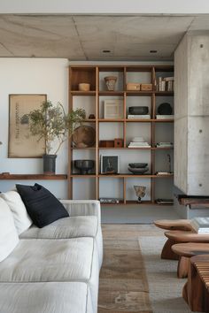 a living room filled with furniture and bookshelves next to a wall full of shelves