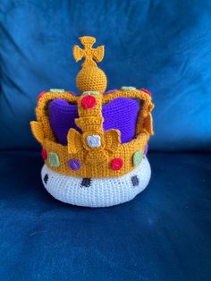 a crocheted crown sitting on top of a blue couch