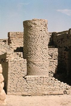 an old brick building in the desert with no people around it and one person standing outside