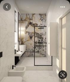 a bathroom with marble walls and flooring next to two sinks in the same room