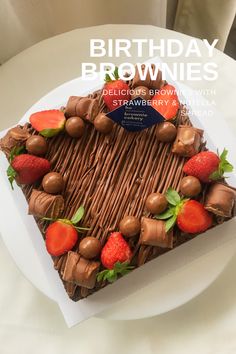 a piece of chocolate cake with strawberries on top and the words birthday brownies above it