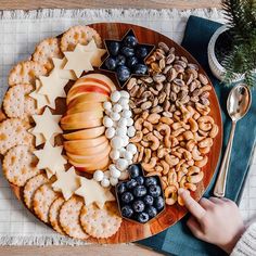 a plate filled with crackers, fruit and nuts