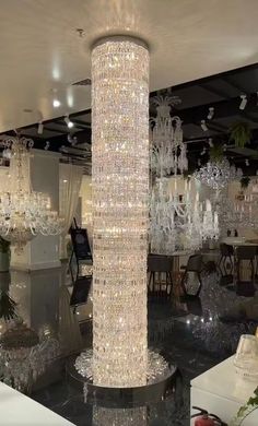 a large chandelier hanging from the ceiling in a room filled with tables and chairs