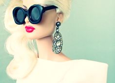 a mannequin head wearing black sunglasses and a white dress with pearls on it