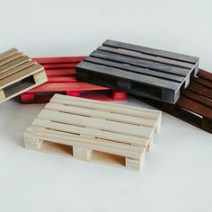 four wooden pallets sitting next to each other on a white tablecloth covered surface