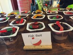 there are many desserts in plastic cups on the table with a sign that says fisk bat