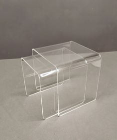 two acrylic boxes sitting on top of each other in front of a gray background