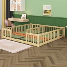 a baby's room with green walls and wood flooring, including a wooden crib