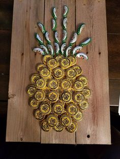 a pineapple made out of beer bottle caps sitting on top of a wooden board