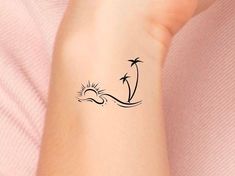 a woman's arm with a small palm tree tattoo on it