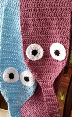 two crocheted scarves with eyes on them