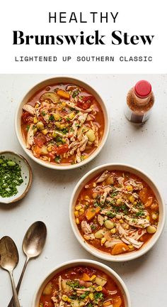 three bowls filled with soup next to spoons