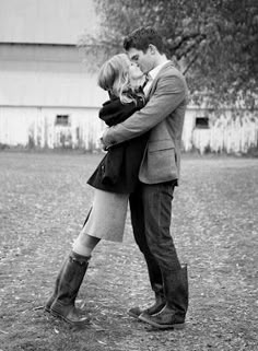 a man and woman are kissing in the rain with their arms wrapped around each other