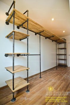 an empty room with some shelves on the wall and wood flooring in front of it