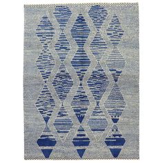 a blue and white rug with diamond shapes on the front, in different shades of blue