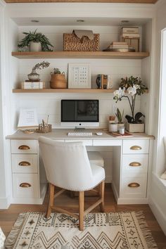 a white desk with a computer on top of it and some plants in the corner