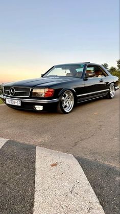 a mercedes benz coupe parked on the side of the road