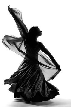 a black and white photo of a woman in a flowing dress with her arms outstretched