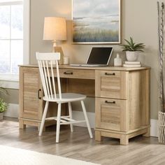 a wooden desk with a laptop computer on top of it next to a white chair