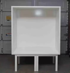 a white shelf sitting on top of a wooden table in a room filled with boxes