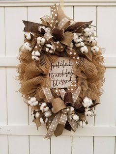 a wreath on the front door with cotton and burlocks