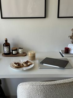 a white table topped with a plate of food next to a bottle of booze