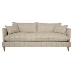 a beige couch with two pillows on it's back and one arm folded up