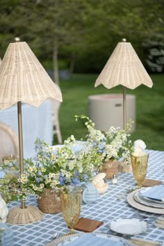 the table is set with blue and white plates, silverware, and umbrellas