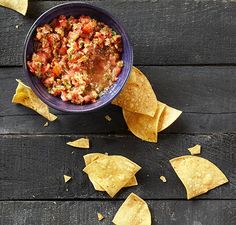 a blue bowl filled with salsa next to tortilla chips