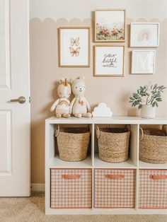 a teddy bear sitting on top of a white shelf next to baskets filled with toys