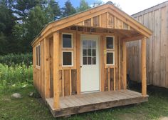 a small wooden cabin with windows and doors