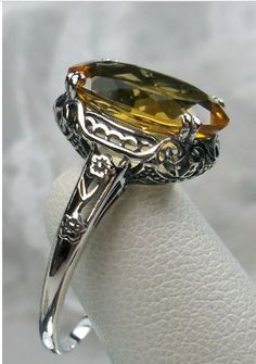 Here we have an Edwardian reproduction ring in sterling silver filigree with a lovely Natural/genuine (4ct to 5ct) Yellow Citrine gemstone solitaire. This full cut oval gem is 14mm in length and 10mm in width. This ring also sits 7mm off the finger. The inside of the band is marked 925 for solid sterling. Notice the beautiful leaf design of the silver filigree setting and etched band. Yellow Citrine Ring, Edwardian Ring, Yellow Citrine, Citrine Ring, Sterling Silver Filigree, Natural Citrine, Citrine Gemstone, Filigree Ring, Favorite Rings