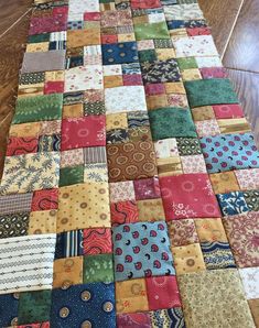 a very large patchwork quilt is laying on the floor