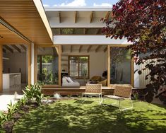 an outdoor living area with grass and wooden furniture