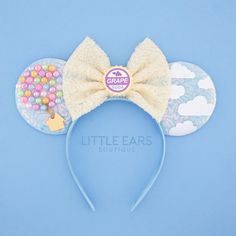 a mickey ears headband with candy on it and a white bow at the top