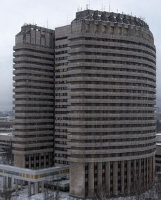 two tall buildings in front of a cloudy sky