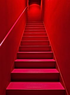 red stairs leading up to the light at the end of each step in a dark room