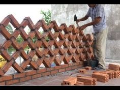 a man working on a fence made out of bricks