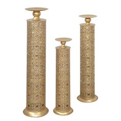 three gold candlesticks are standing next to each other on a white background,