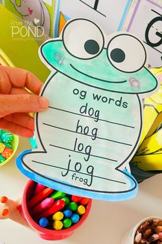 a child's hand holding up a sign that says dog words and has candy in it