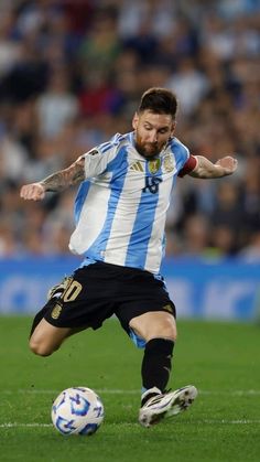 a man kicking a soccer ball on top of a field