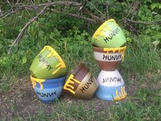 three painted eggs sitting on top of each other in front of some grass and bushes