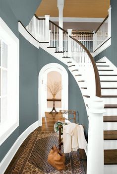 a white staircase with blue walls and wooden floors