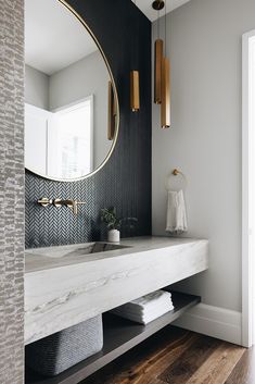 a bathroom with marble counter tops and gold accents