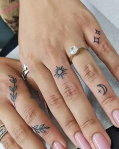 two people with tattoos on their fingers and one has a diamond ring in the middle