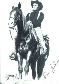 an old black and white photo of a man on a horse wearing a cowboy hat