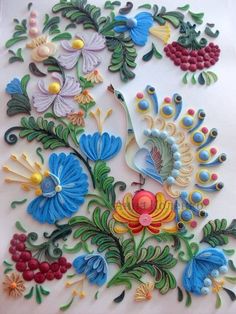 an intricately designed piece of paper with flowers and peacocks on the side, surrounded by grapes