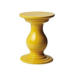 a yellow vase sitting on top of a white table