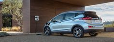 the rear end of a silver honda cr - v parked in front of a building