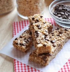 three granola bars sitting on top of a red and white checkered napkin